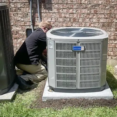 Technician from American Heritage Air performs AC repair service for a customer.